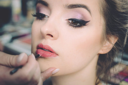 makeup artist putting on lipstick