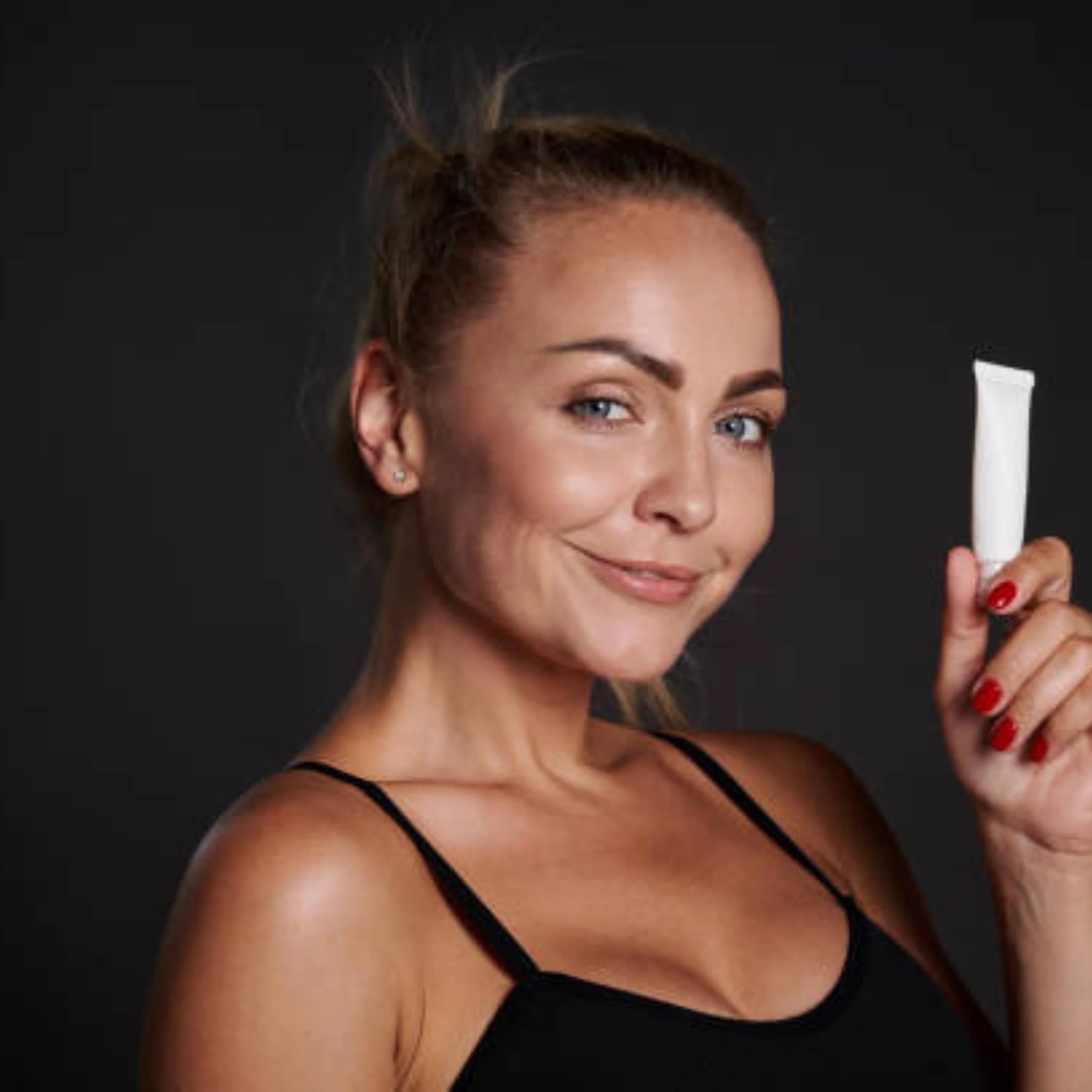 woman holding a tube of skincare cream