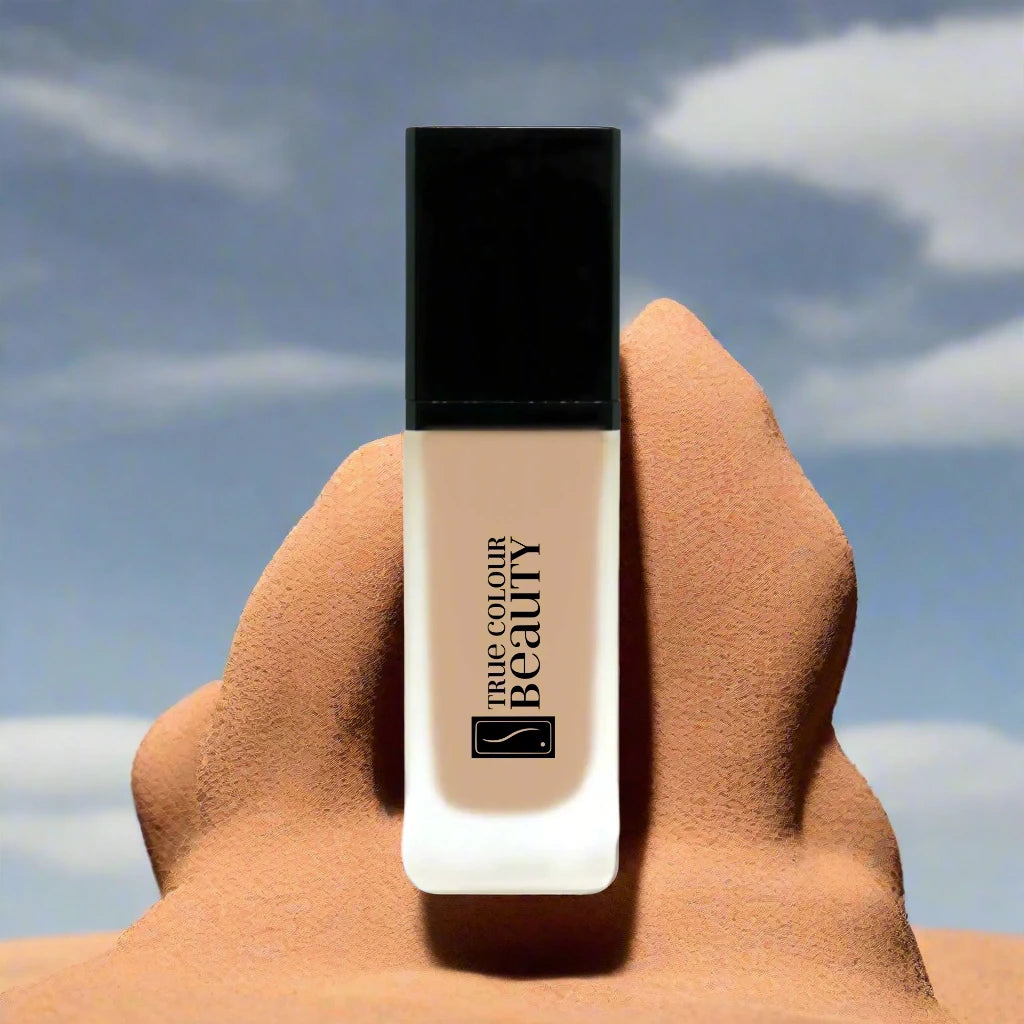 Earthbound Liquid Foundation - Sandstone, shown in a recyclable white bottle with black lid, offering buildable coverage for a radiant, breathable complexion.