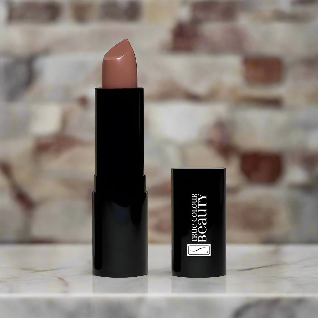 Blissful Beige lipstick displayed elegantly on a marble countertop with soft lighting.