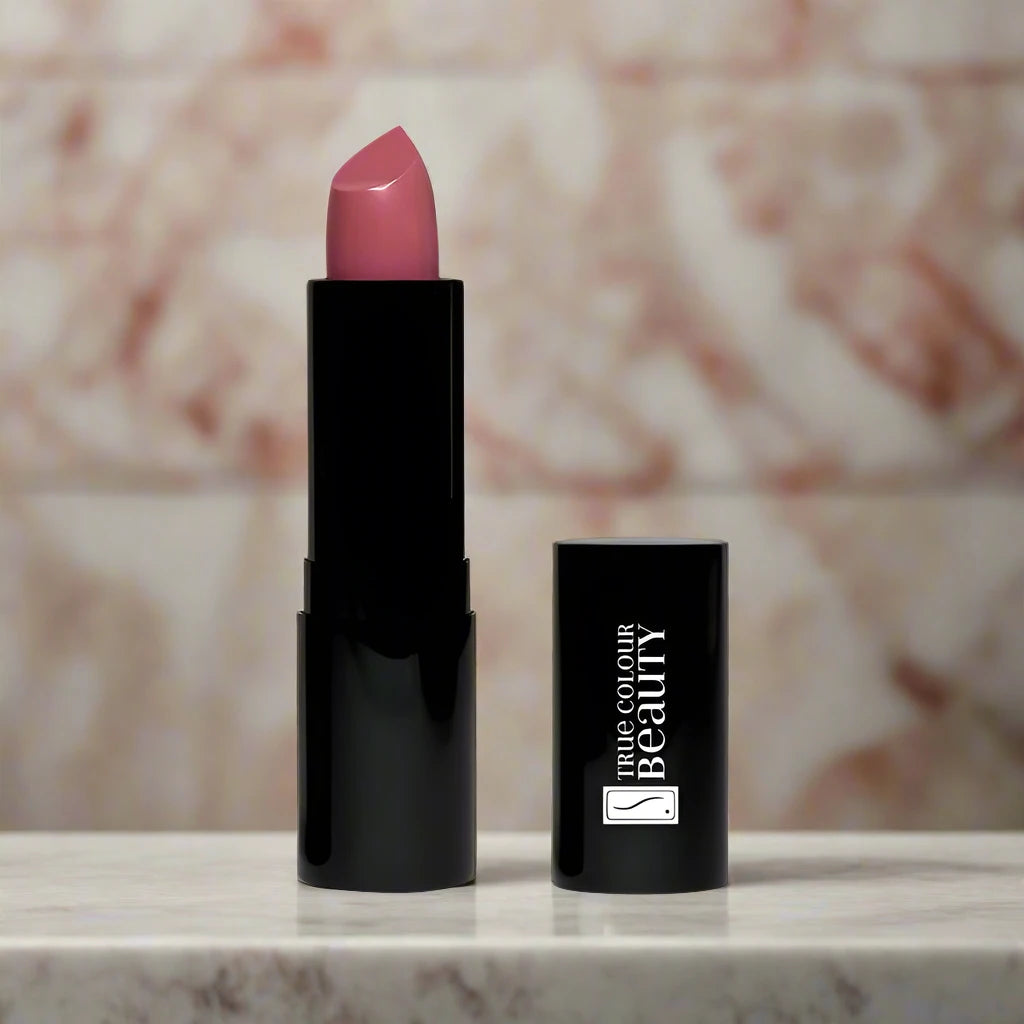 Dreamy Orchid lipstick displayed on a marble countertop against a brick wall backdrop