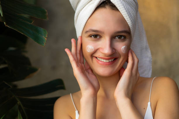 woman putting skincare on face