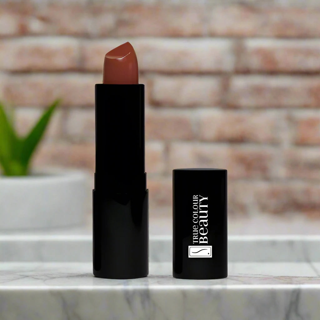 lipstick tube in front of a brick wall on a marble countertop